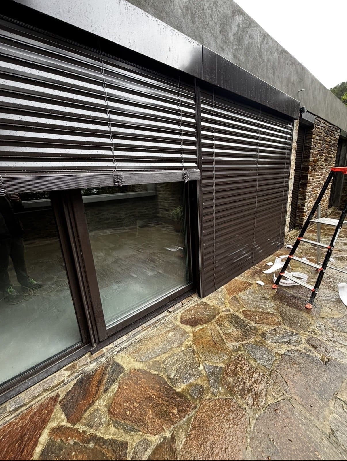 Volets roulants en aluminium et baie coulissante posés sur une maison contemporaine